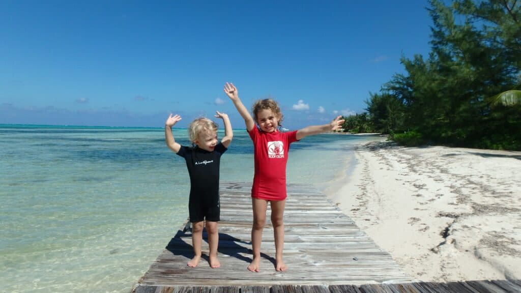 The best Grand Cayman family vacation with kids enjoying the crystal clear beaches.