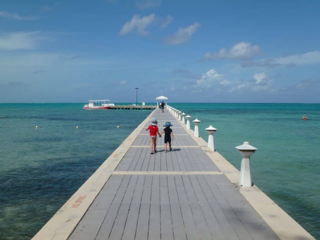 Walking out to take a boat tour in Rum Point with visiting the Cayman Islands with kids.