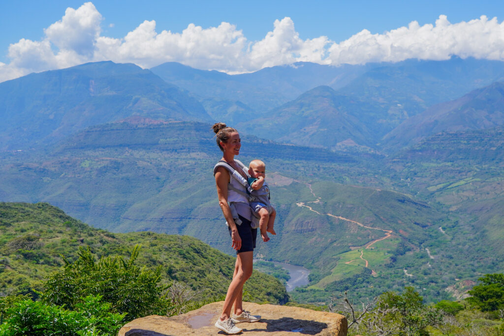 Michelle and baby on a cliff looking out over the mountains in Colombia. There are so many gorgeous regions to discover during your Colombia 3 week itinerary.