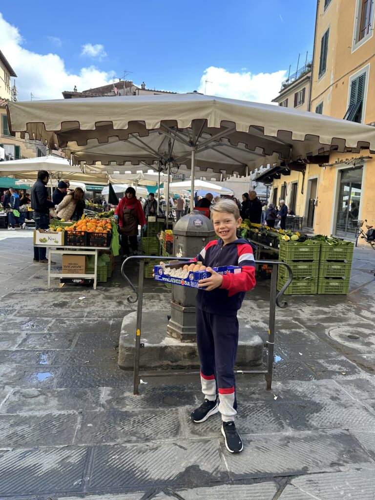 Buying fruits, veggies and eggs at the local Sunday market in Pistoia Italy.