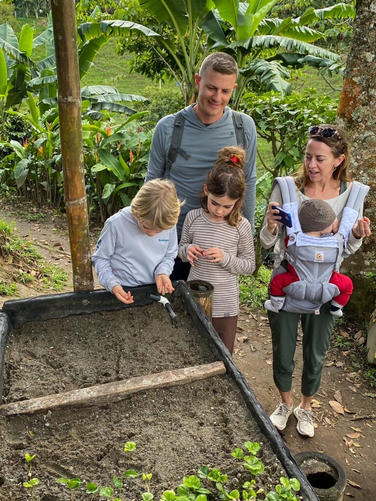Family of five on planting coffee seeds on a coffee tour at a farm outside of Medellin Colombia.