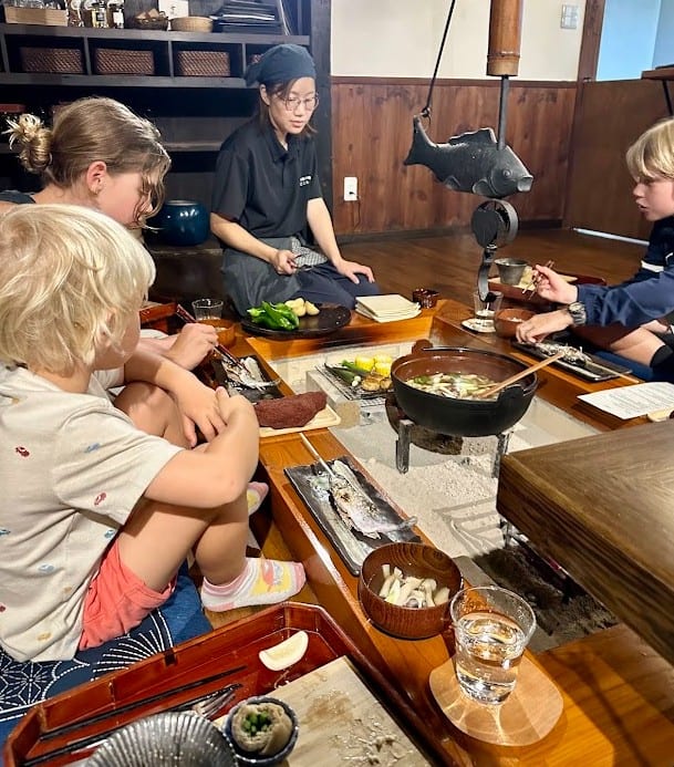 Family enjoying at traditional Irori Japanese dinner at Magokoro Inn.