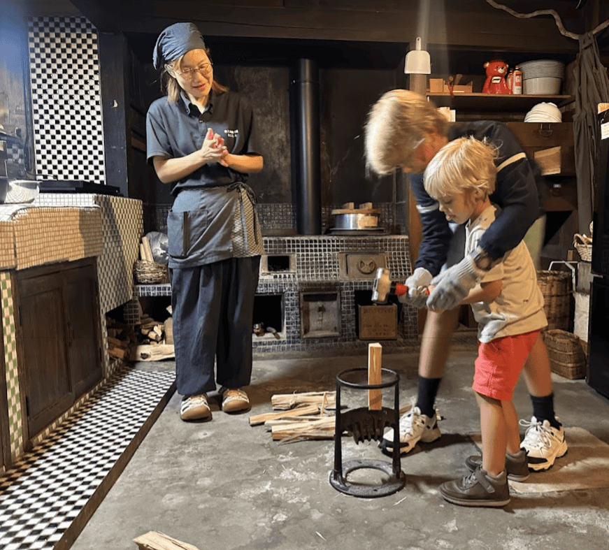 two brothers chopping wood for the fire at Magokoro Inn in Japan, a unique stay for families with kids